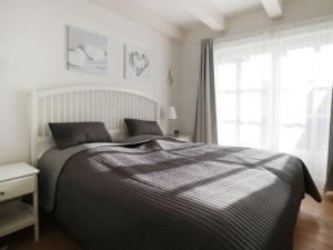 a bedroom with a bed and a large window at Strandkörbchen in Groß Schwansee