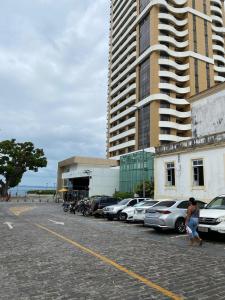 un parcheggio con auto parcheggiate accanto a un edificio alto di casinhavila130 a Salvador