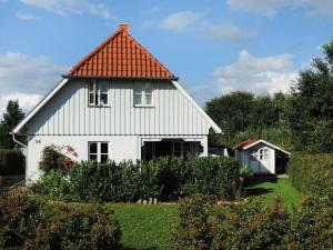 a white house with an orange roof at Strandkörbchen in Groß Schwansee