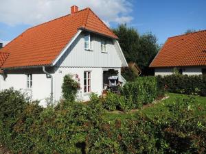 a white house with an orange roof at Strandkörbchen in Groß Schwansee
