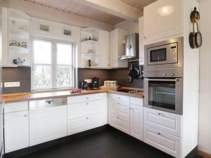 a white kitchen with white cabinets and a window at Strandkörbchen in Groß Schwansee +23 photos