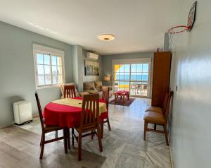 a dining room and living room with a table and chairs at Seaview apartment Peñoncillo in Torrox Costa +8 photos