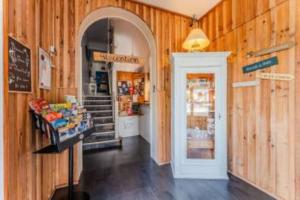 a shop with wooden walls and a hallway with a doorway at Hôtel Le Grain de Sable in Arès