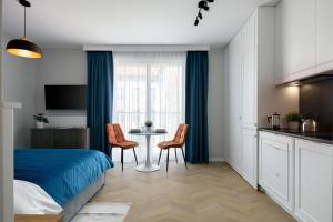 a bedroom with a bed and a table and chairs at Metropolis Old Town Apartments in Kraków