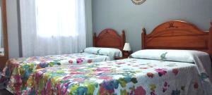 a bedroom with two beds and a window at Los Álamos in Mérida