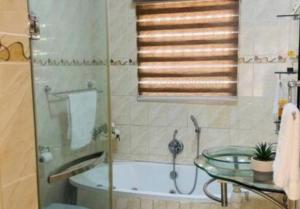 a bathroom with a tub and a glass table at C-rane guesthouse in Phalaborwa