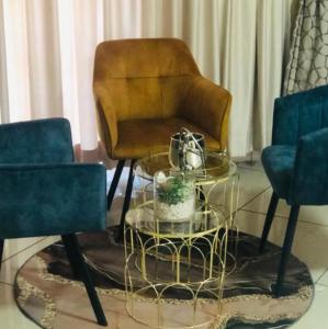 a living room with a chair and a glass table at C-rane guesthouse in Phalaborwa