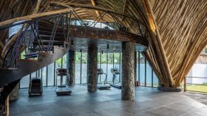 a gym with several treadmills and a staircase in a building at Kumbara Villas in Kuta Lombok