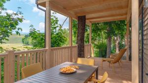 a porch with a table and chairs on a deck at Camping Village Ekar Asiago in Asiago