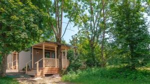 a small cabin in the woods with trees at Camping Village Ekar Asiago in Asiago