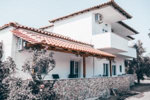 a white house with a stone wall at Villa Theano 2 in Toroni