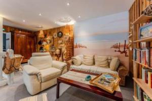 a living room with a couch and a coffee table at Hôtel Le Grain de Sable in Arès