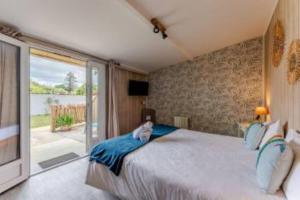a bedroom with a large bed with a dog sitting on it at Hôtel Le Grain de Sable in Arès