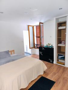 a bedroom with a bed and a wooden floor at Apartament in Villiers-sur-Marne