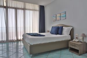 a bedroom with a large bed with blue pillows at Hotel Centro Congressi Polo Nautico in Salerno