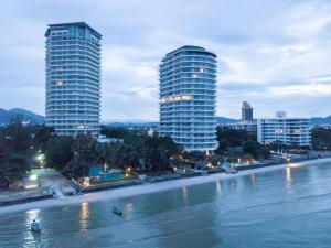 华欣120 sqm Beachfront Condo的水域旁的两座高楼