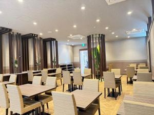 a dining room with tables and white chairs at Dormy Inn Premium Shibuya-jingumae in Tokyo