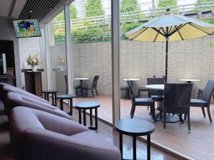 a restaurant with tables and chairs and an umbrella at Dormy Inn Premium Shibuya-jingumae in Tokyo