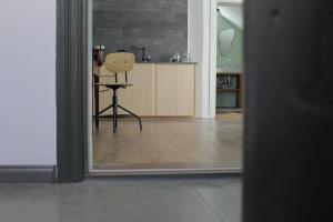 a view of a room with a chair and a kitchen at Skrundas ielas apartamenti in Kuldīga