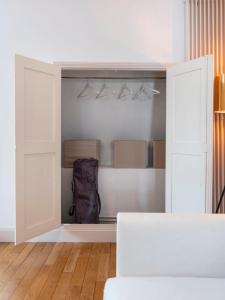 een kast met witte deuren en een rugzak erin bij Le prestige de Poincare in Nancy