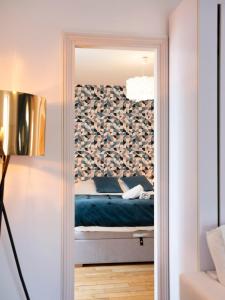 een slaapkamer met een bed door een spiegel bij Le prestige de Poincare in Nancy