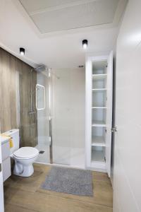 Un baño con inodoro y ducha de cristal. en Apartamento Palermo Living Suites en Burriana, en Burriana 32 fotos más
