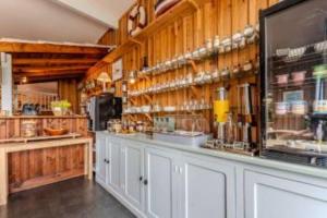a kitchen with wooden walls and a counter in a room at Hôtel Le Grain de Sable in Arès