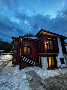 a small house with lights in the windows at Ethno Villa Cherry in Cherven