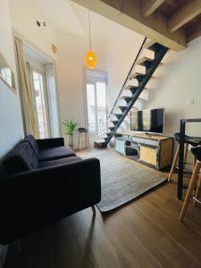 un soggiorno con un divano e una TV di Magnifique Loft sur 2 niveaux Comédie Gare a Montpellier