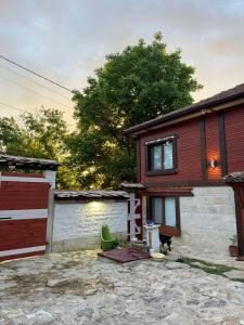 a house with a fence and a garage at Ethno Villa Cherry in Cherven