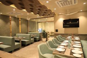 a dining room with a long table and chairs at Hotel Rich Comfort Ajmer in Ajmer
