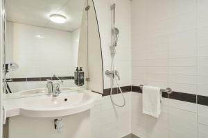 a white bathroom with a sink and a shower at ibis budget Issy Les Moulineaux Paris Ouest in Issy-les-Moulineaux