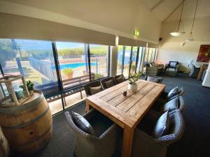 a room with a wooden table and chairs and a large window at Surfpoint Resort in Margaret River Town