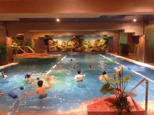 a group of people swimming in a swimming pool at Apartament 3 camere de lux in Bucharest