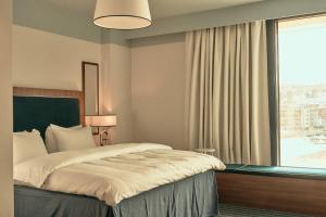a bedroom with a bed and a large window at Hotel Klubben in Tønsberg