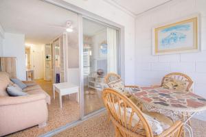 a living room with a table and chairs and a couch at Serisol Holidays in Benidorm