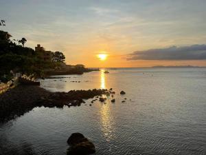 a sunset over a body of water with the sun setting at Bughaw Dive House - Anilao, Mabini, Batangas in Mabini