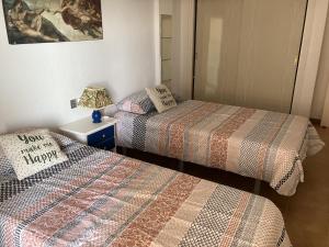 una habitación con dos camas y una mesa con lámpara en Zambra 3 - 411, en La Manga del Mar Menor
