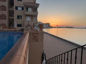 una piscina junto a un edificio y al océano en Zambra 3 - 411, en La Manga del Mar Menor