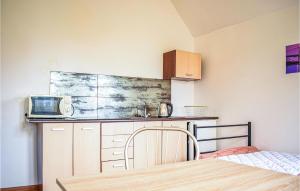 a small kitchen with a table and a microwave at 2 Bedroom Cozy Apartment In Kolobrzeg in Kołobrzeg