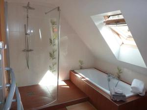 a attic bathroom with a shower and a bath tub at chez Marie et Eric in Dieffenbach-au-Val