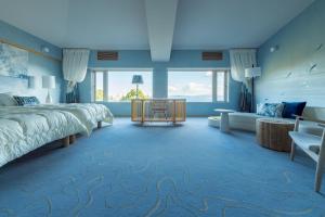 a bedroom with a large bed with a blue carpet at Suite Villa Curation Atami Momoyamagaen in Atami