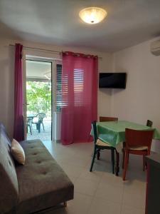 a living room with a green table and a couch at Apartment Roglić in Rab