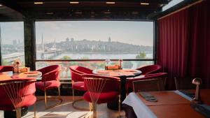 a restaurant with red chairs and tables and a large window at Lale Sultan Hotel in Istanbul