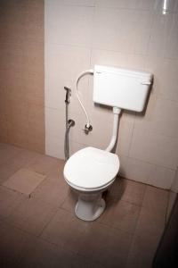 a bathroom with a white toilet in a stall at Coffee Camp Home Stay with Tree house in Kattappana