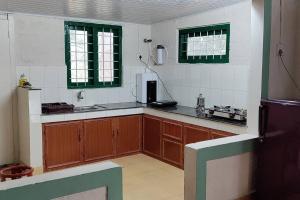 a kitchen with wooden cabinets and green windows at Coffee Camp Home Stay with Tree house in Kattappana +64 photos