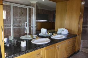 a bathroom with two sinks and a shower at Airport Gardens Boutique Hotel in Boksburg +95 photos