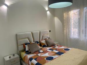 a bedroom with a large bed with a colorful comforter at Logement bord de mer in El Harhoura
