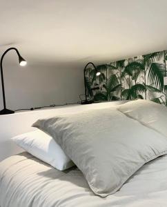 Un dormitorio con una cama blanca con cabecero tropical. en Loft II en Madrid, en Madrid