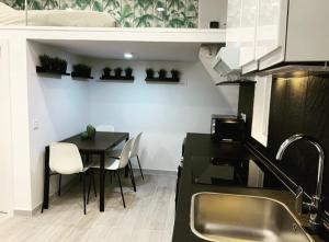Una cocina con una mesa y sillas y un fregadero. en Loft II en Madrid, en Madrid